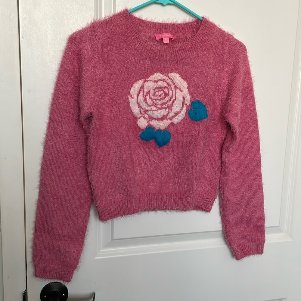 A pink slightly fluffy sweater